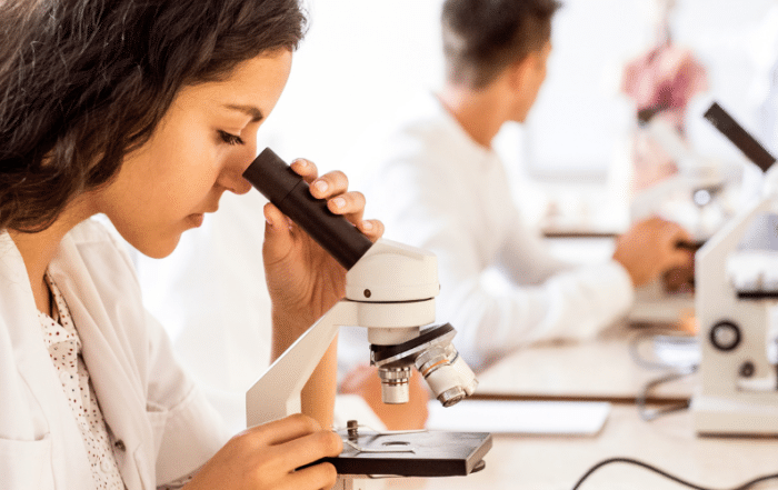 Biology student looking into microscope