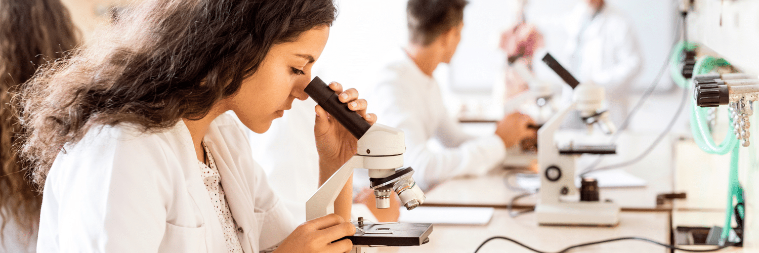 Biology student looking into microscope