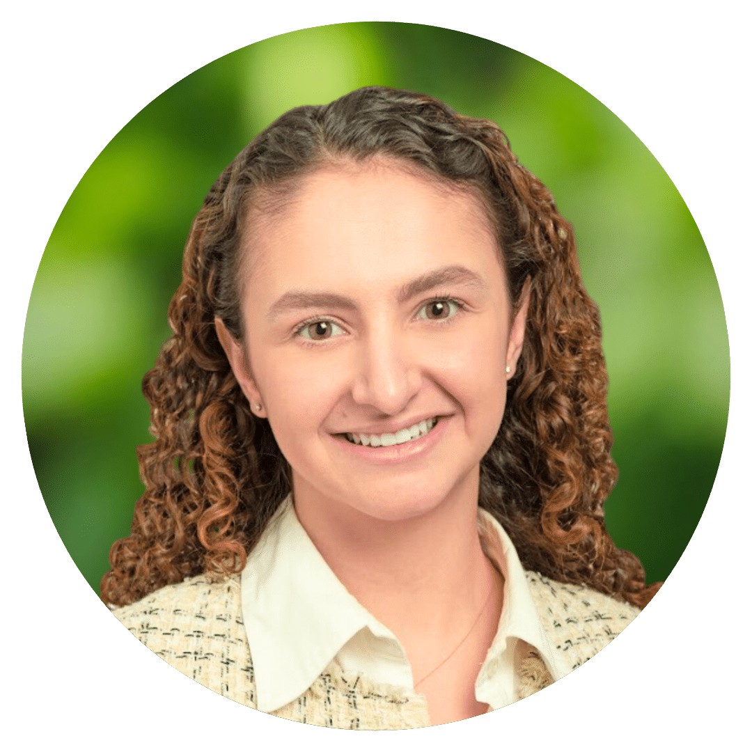 Circle cutout of Demre I.'s professional headshot, with a background of leaves