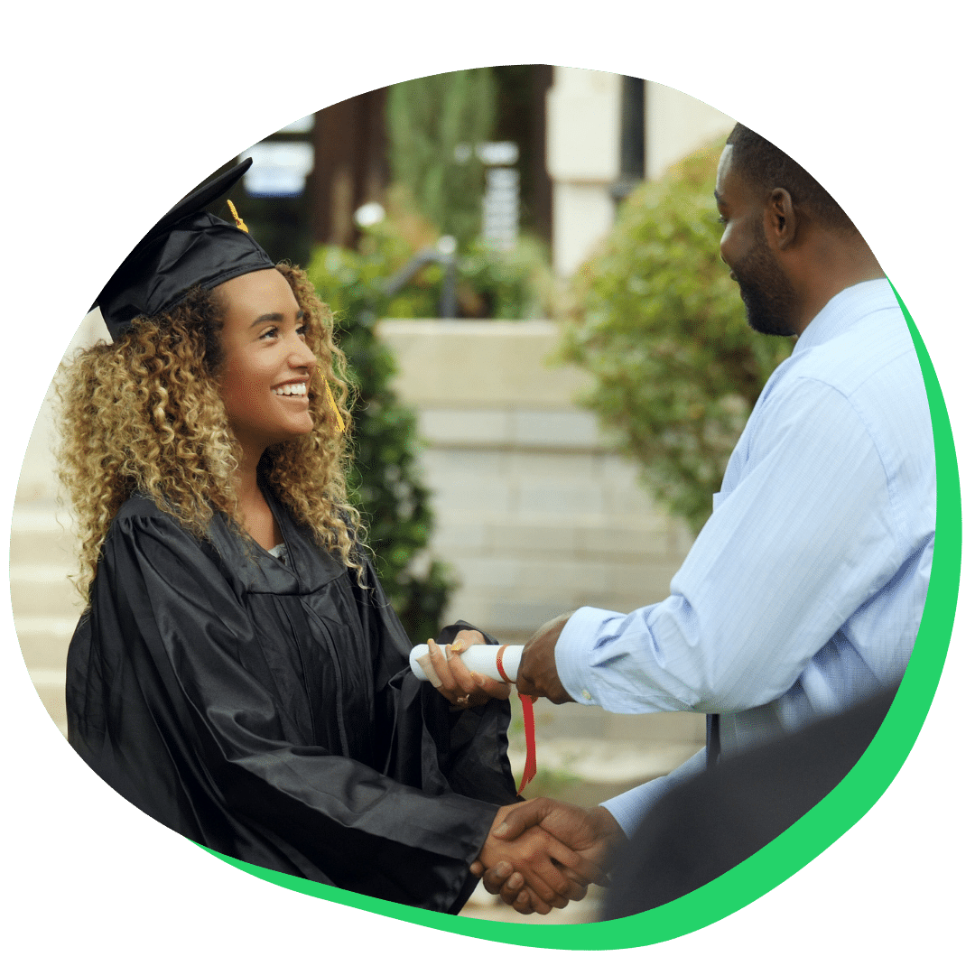 High school student shaking teacher's hand at graduation