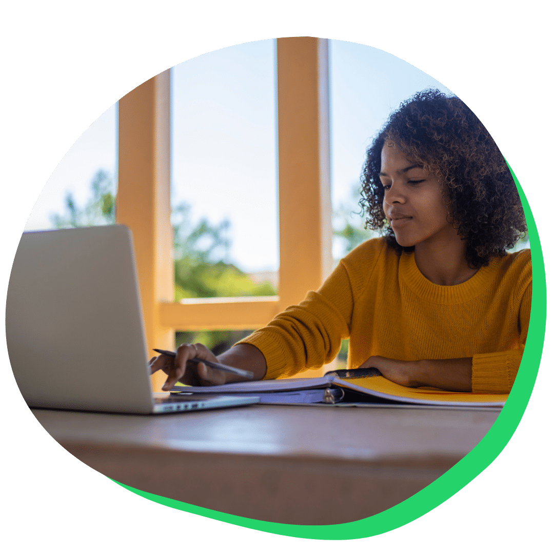 Female student with yellow sweater working on laptop