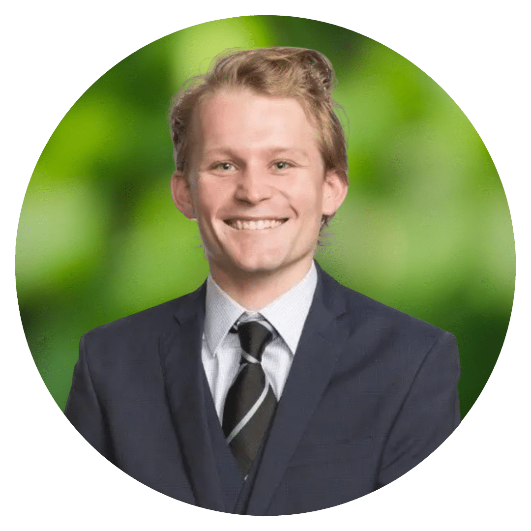 Circle cutout of Guy F.'s professional headshot, with a background of leaves