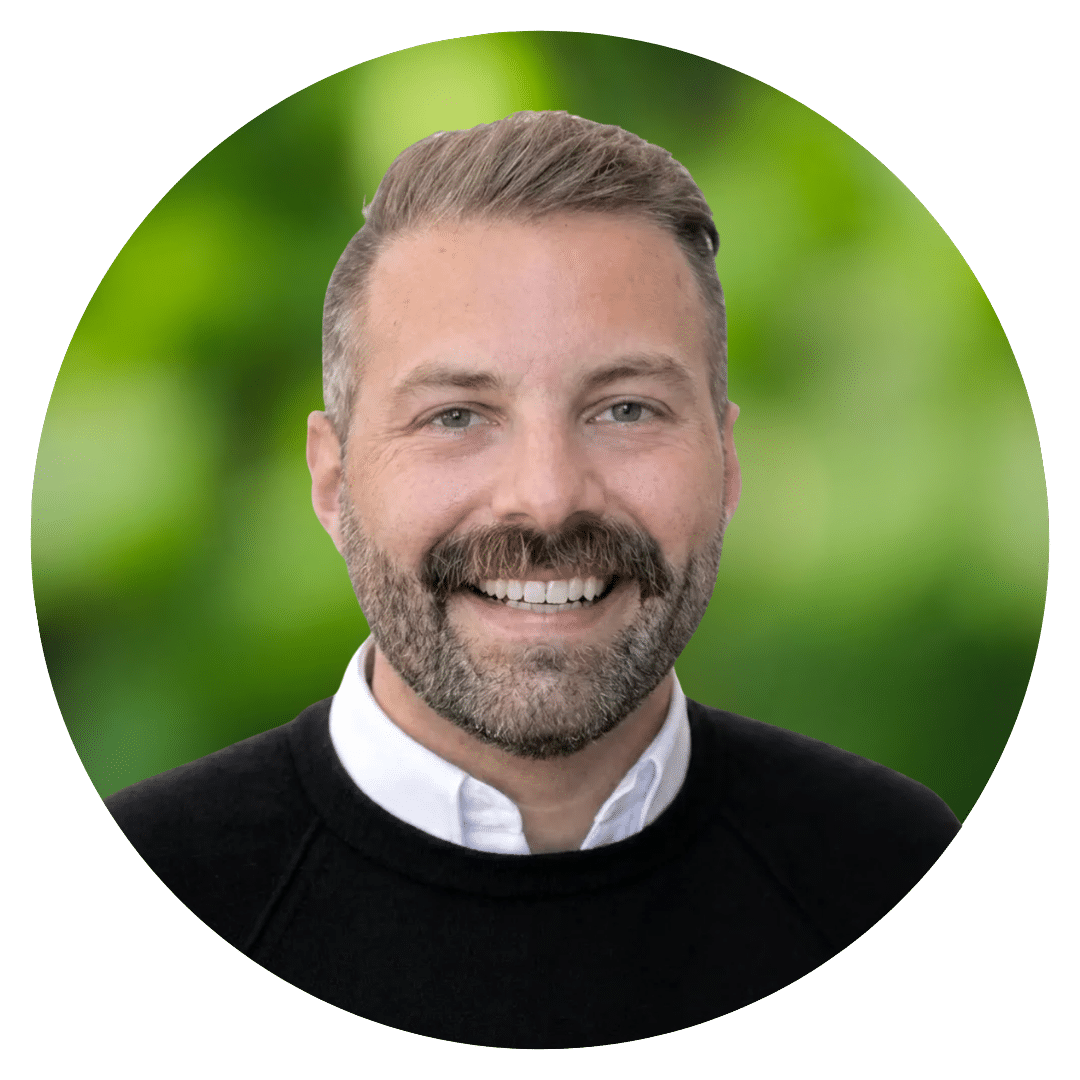 Circle cutout headshot of Prepory Coach Shane V.D. behind a blurred background of green leaves